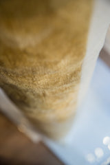 Soft focus detail of the woven ivory side fabric on the lumbar pillow.