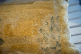 Close-up of the antique Chinese rug fragment pillow's golden pile, subtle blue design, and visible stitching.