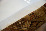 Pillow side detail: Antique Caucasian rug fragment, showing dense geometric pile and neutral woven backing.