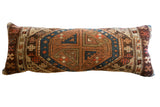 Hand-knotted antique Caucasian rug fragment pillow, geometric medallion in browns, rust, and indigo, 13x36.