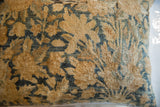Antique Kerman rug fragment pillow featuring aged golden-tan and teal botanical design.