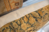 Antique Persian rug fragment pillow's textured golden and slate blue curvilinear pattern meets solid beige fabric.