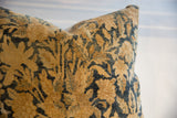 Antique Kerman fragment pillow showcasing textured golden beige and deep indigo floral design.