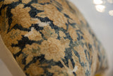 Antique Persian Kerman fragment pillow's textured pile, showing golden tan and deep teal motifs.