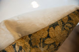 Antique Kerman rug fragment pillow showing golden textured pile and neutral linen backing.