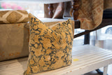 Intricate floral pattern in tan and deep blue on the antique Persian Kerman pillow.