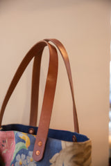 Brown leather handles and copper rivets on the vintage floral market tote.