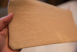 Vintage clutch's beige, tight woven fabric texture, held by hand.