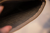 Vintage clutch interior with finely woven dark lining fabric and brass zipper.
