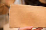 Plain textured beige fabric on the back of the vintage clutch.