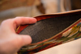 Southport clutch interior, featuring dark gray lining and rich red zipper.