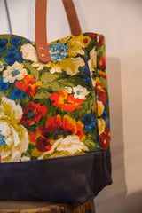 Vintage floral fabric tote bag displaying vibrant red, blue flowers and dark canvas base.