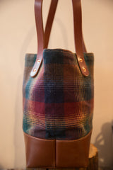 Vintage gradient plaid fabric in earthy tones, paired with a rich brown leather bucket base.