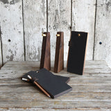 Walnut wood Peg and Awl tablet stands with black chalk tablets and writing tools.