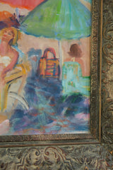 Ornate carved frame bordering a vibrant painted beach scene with green umbrella.