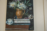 White teacup and saucer next to books in Grace B. Keogh 
