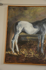 White and gray horse's legs, body, and straw-like ground with simple wood frame.