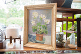 Detailed view of white flowers, green leaves, and the painting's texture in ornate frame.