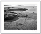 Black and white photograph of a Maine coastal landscape showing a small boat on a grassy shoreline.