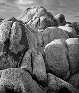 High-contrast light and shadow define the bulbous forms of large, weathered granite rocks.