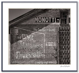 Framed black and white photograph of a vintage Levi Strauss sign on a rustic building wall.