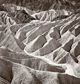 Detail view of the photograph's textured badlands, showing sharp ridges and deep shadows.