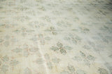 Blanched distressed Oushak carpet with angular pale green clover motif detail.