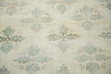 Close-up of distressed Oushak carpet featuring blanched clover motifs and angular design.
