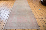 Distressed texture of a pink Oushak runner with subtle geometric patterns.