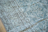 Distressed Oushak carpet texture with blanched ocean green, beige, and faded motifs.