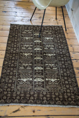 Detail of pictorial Afghan war rug, showing cars and geometric border in brown and beige.
