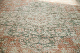 Faded blanched rust terra cotta, silver, and ivory patterns on a distressed Oushak carpet.