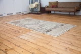 Neutral vintage Oushak rug showcasing bold geometric patterns and fringe.