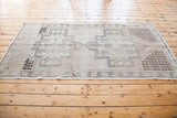 Neutral geometric border and light fringe on the vintage Oushak rug.