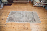 Vintage Oushak rug corner with neutral geometric pattern and cream fringe.