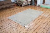 Subtle light and airy vintage Oushak rug corner with faint traditional motifs.