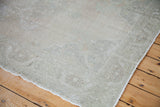 Subtle light ivory and soft sage tones on the vintage Oushak rug's thin pile.