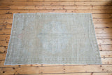 Subtle light-toned vintage Oushak rug with a faded medallion pattern and soft texture.