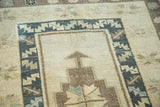 Textured pile of geometric vintage Oushak rug with muted cream, brown, and slate tones.