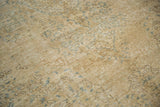 Textural close-up of distressed Oushak carpet with airy beige and subtle blue motifs.