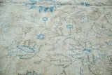Distressed Oushak carpet pile with airy cream, faded blue, and green floral patterns.