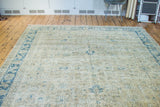 Distressed Oushak carpet with airy beige field and soft blue sprawling floral motifs.