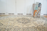 Blanched field and contrasting ornate patterns of the vintage Oushak carpet.