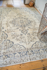 Blanched cream field, faded blue outlined pattern, and border of the Vintage Oushak carpet.