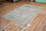 Light, airy vintage Oushak carpet with muted beige, grey, and slate blue.