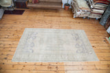 Light, airy vintage Oushak carpet in beige, grey, and soft slate blue tones.