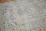 Soft, faded beige and grey-blue motifs on a vintage Oushak rug's pile.