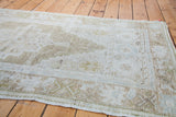 Subtle geometric motifs and blanched bronzy hues in a section of the vintage Oushak rug.