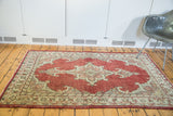Traditional Oushak rug corner, featuring bold cherry red with ivory and slate grey motifs.
