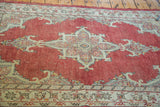 Bold ivory and slate grey medallion pattern on a cherry red vintage Oushak rug.